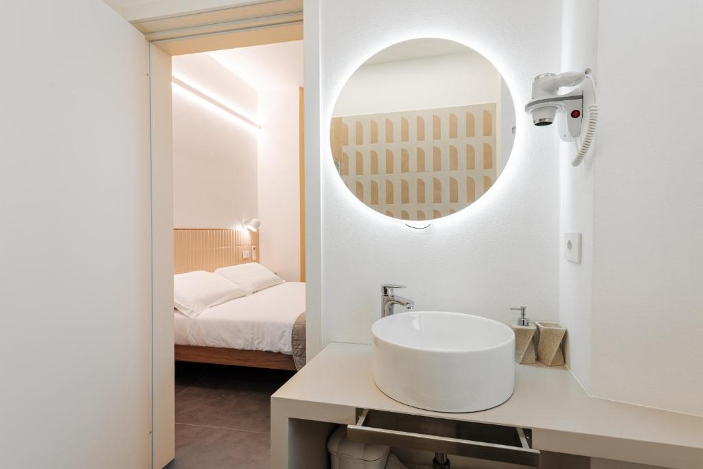a white bathroom with a sink and a mirror at Le camere in città in La Spezia