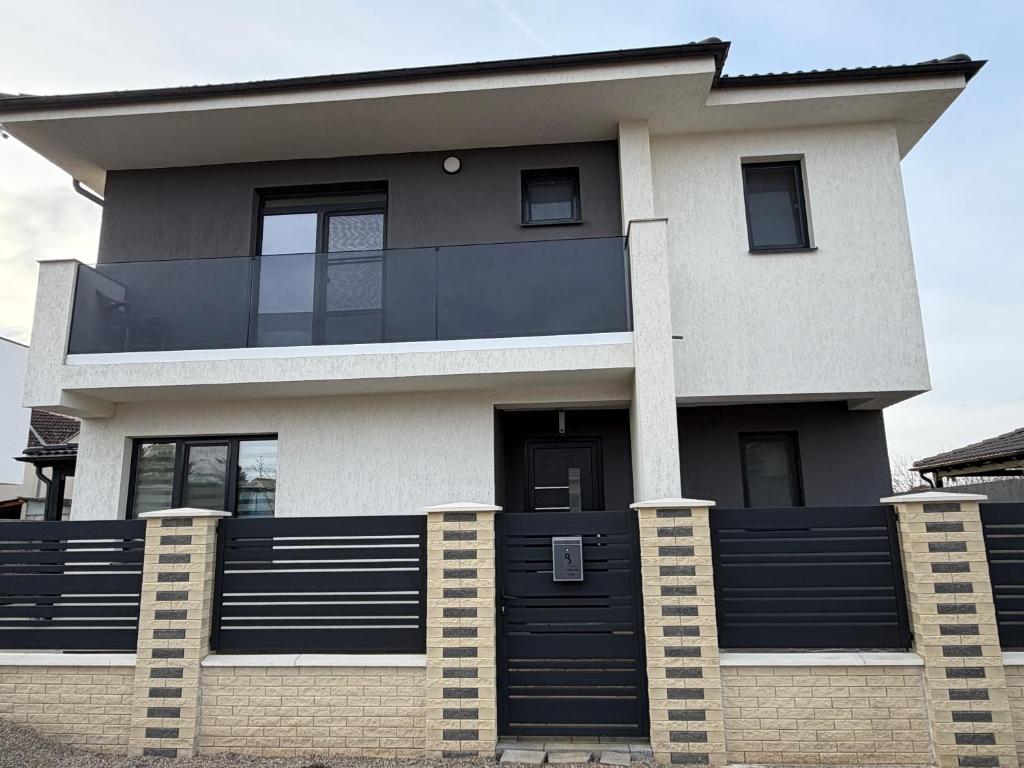 een huis met een zwarte deur en een hek bij California Home in Odoreu