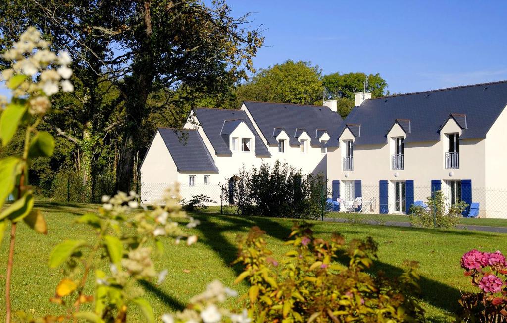 une grande maison blanche avec un toit noir dans l'établissement Résidence Odalys Horizon Morgat, à Crozon