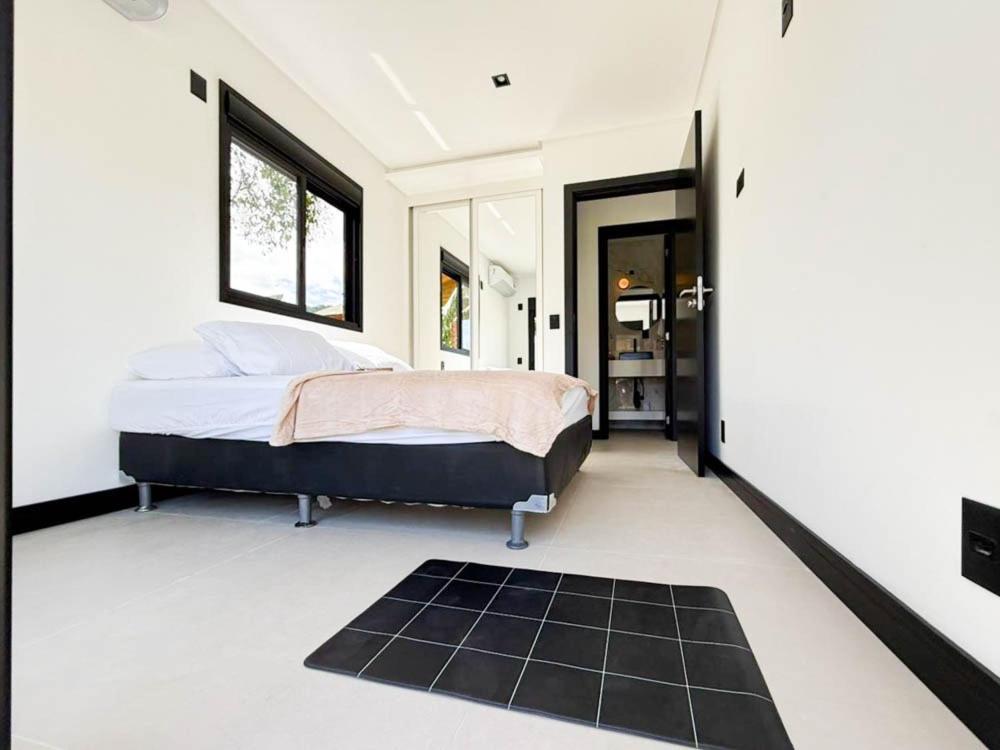 una camera con un letto e un tappeto nero di Vila do Sol a Florianópolis