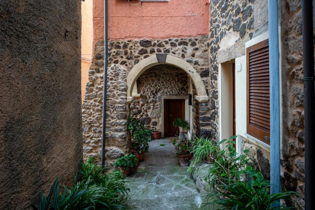 een boog in een stenen gebouw met potplanten bij Guest House - Appusentu in Castelsardo