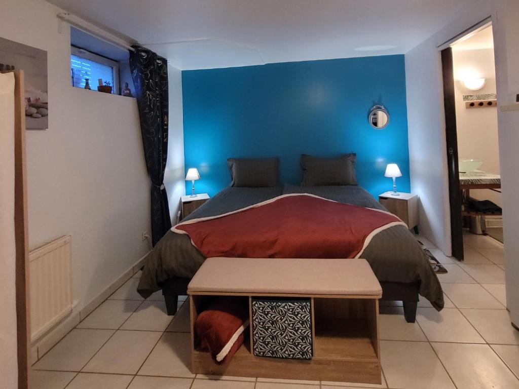 ein Schlafzimmer mit einem Bett und einer blauen Wand in der Unterkunft À la campagne, studio 25m2-pour 2 au calme, wifi, jardin, parking in Yèvres