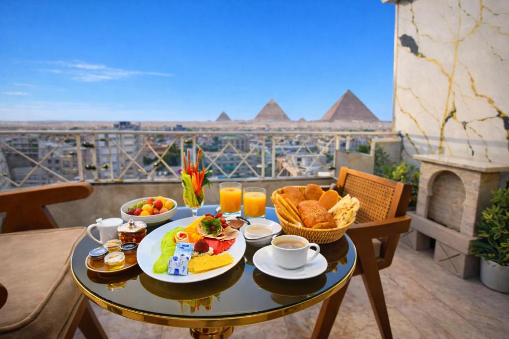 een tafel met ontbijt en uitzicht op de piramides bij Zoom Pyramids View inn in Caïro