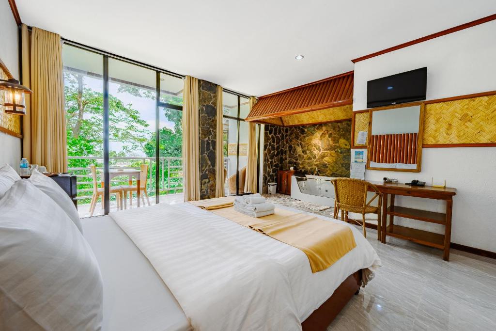 a bedroom with a large white bed and a desk at El Nido Viewdeck Cottages in El Nido