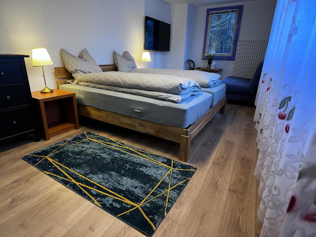 een slaapkamer met een bed en een tapijt op de vloer bij Studio apartment - Park view in Thun