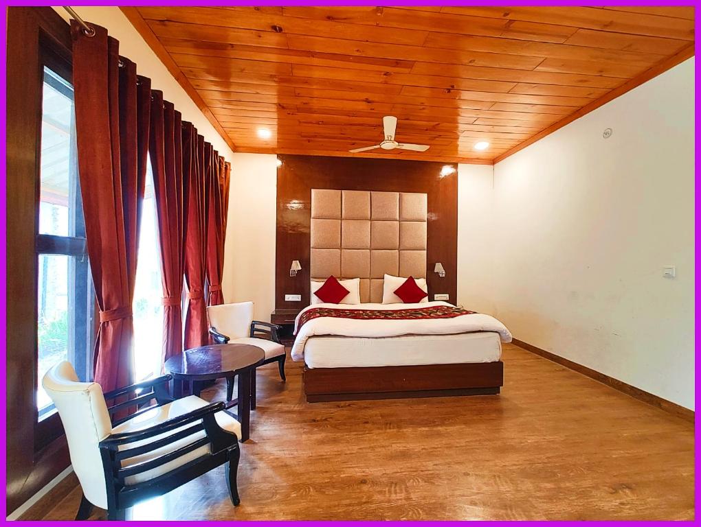 una camera da letto con un letto, una scrivania e un tavolo di Hotel Saanidhya Blue Moon Palace Inn Near Bhimtal Lake- Wifi - Room Service - Parking Facilities - Velly view Hotel a Nainital