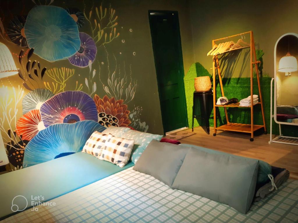 een slaapkamer met een bed in een kamer met een muurschildering bij Homestay GÁC MƠ Vũng Tàu in Vung Tau