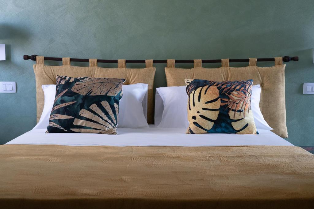 a bed with pillows on it with a white bedspread at TAGA Rooms in Catania
