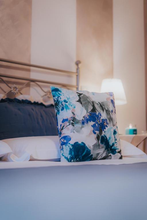 a blue and white pillow sitting on top of a bed at Affittacamere Casa Mac & Rose in San Quirico dʼOrcia