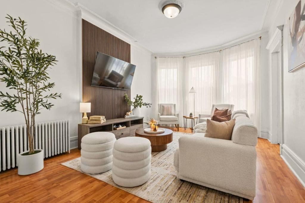 a living room with a couch and a tv at The Caleb Loft near Manhattan with NYC skyline view in Hoboken