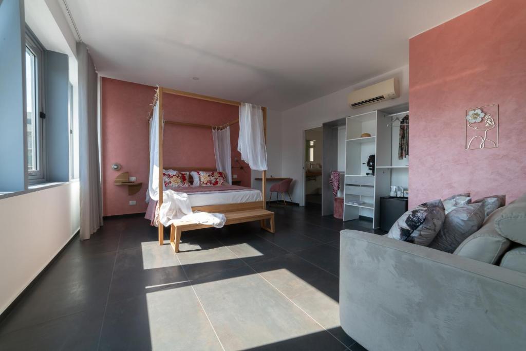 een slaapkamer met een bed en een bank in een kamer bij Namuri Catania Centro in Catania