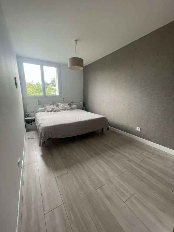 a bedroom with a bed and a large window at Chambre meublée avec dressing dans un grand appartement tout équipé au pied du tram cher habitant in Lormont