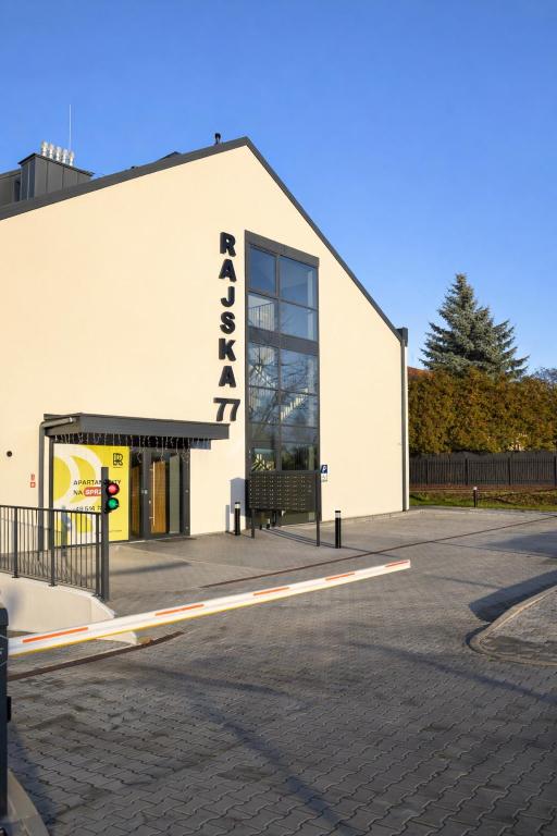 a white building with a sign on the side of it at Apartments Rajska 77 in Wrocław