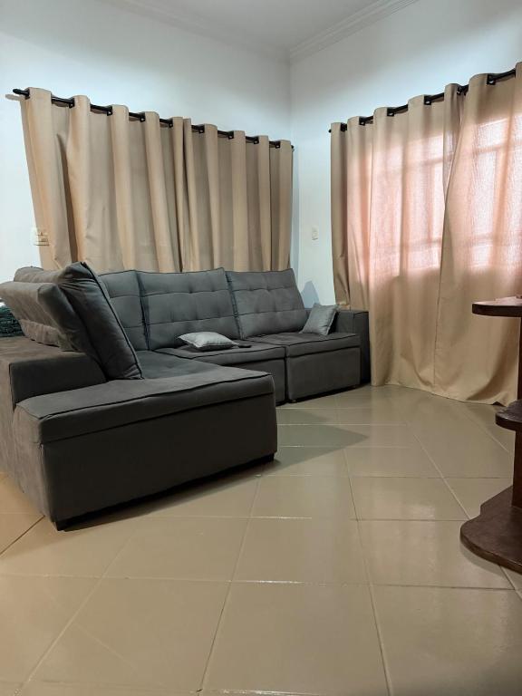 a blue couch in a living room with curtains at Chácara Ana Clara in Cotia