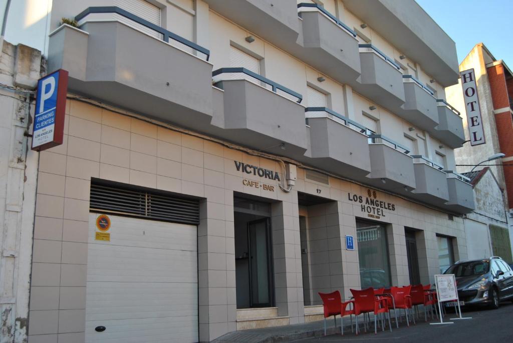 a building with red chairs in front of it at Hotel Los Angeles in Almendralejo