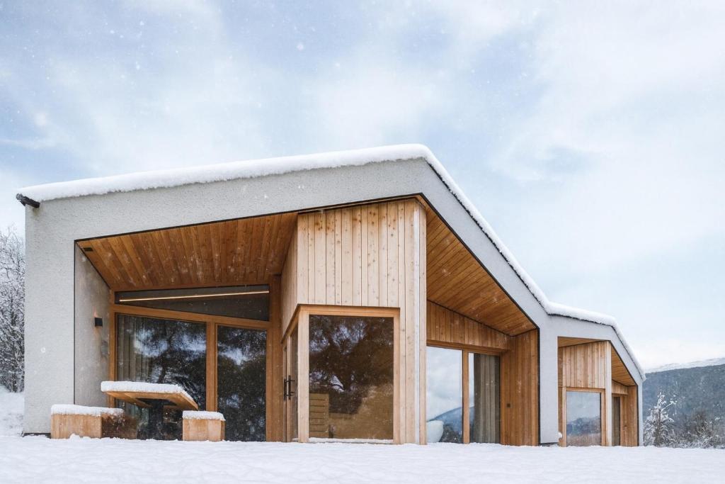 una casa con tetto ricoperto di neve di Oberplunerhof Luxury Chalet Woods a Colli in Pusteria