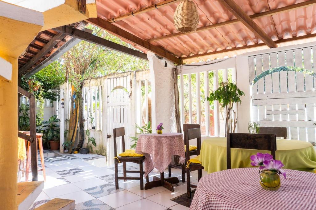 een patio met een tafel en stoelen en een tafel en een stoeltje bij Pousada Rose in Pipa