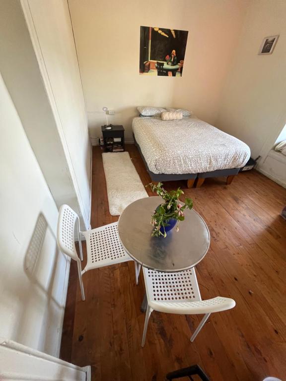 a small room with a bed and a table and chairs at Casa Mirador Pichilemu in Pichilemu