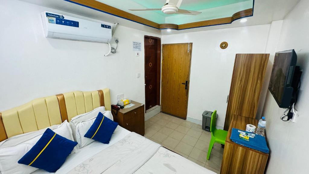 una camera da letto con un letto con cuscini blu e una televisione di Hotel Sweet Place a Gulshan 1