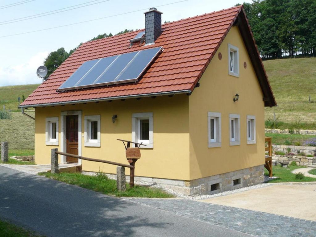 a small yellow house with solar panels on the roof at Hohnstein in Hohnstein