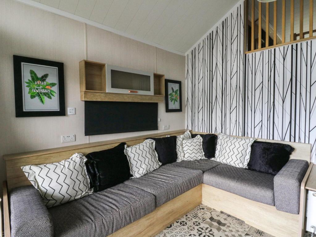 a living room with a couch and a television at The Family Pod - Gower in Swansea