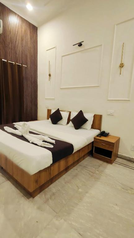 a bedroom with a large bed with a wooden frame at Hotel Laxmi Palace Near ISBT Dehradun in Dehradun