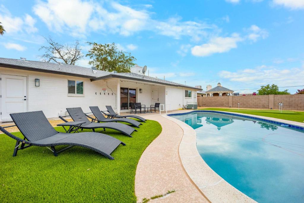 a yard with chairs and a swimming pool at Private Pool Haven Backyard & Putting Green in Phoenix