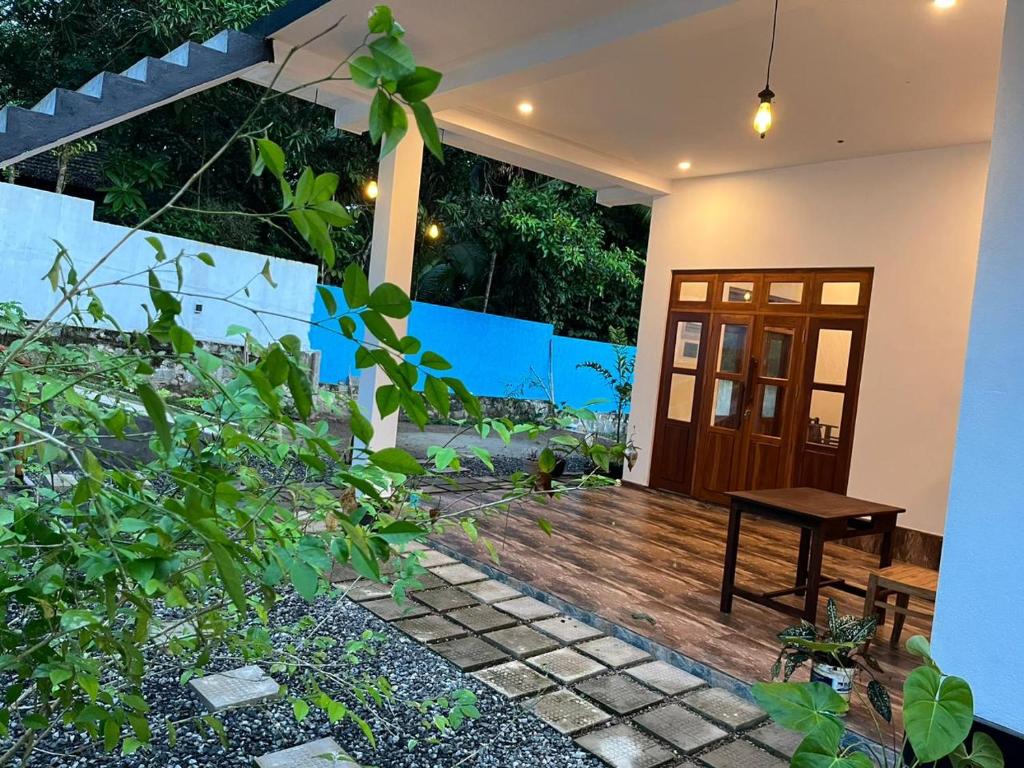 a house with a wooden porch with a wooden table at Lio Villa in Habaraduwa Central