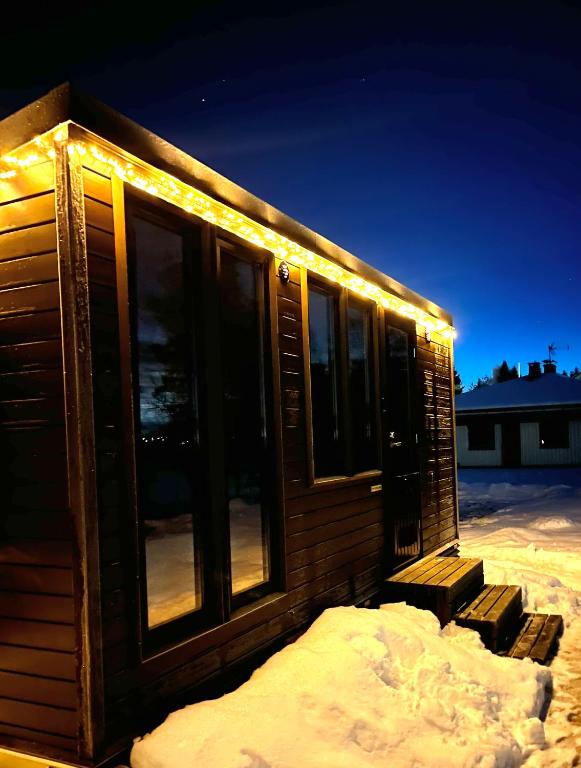 a cabin with lights on it in the snow at The Little Owls Nest in Rovaniemi