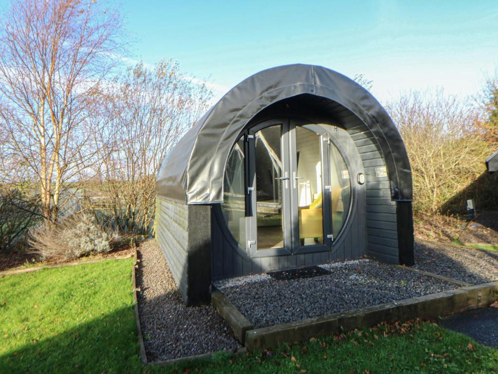 a dome greenhouse in a yard with a lawn at Glamping Pod 9 - Gower in Swansea