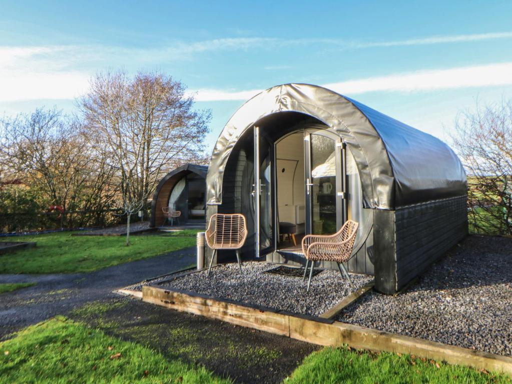 two chairs sitting inside of a dome tent at Glamping Pod 10 - Gower in Swansea