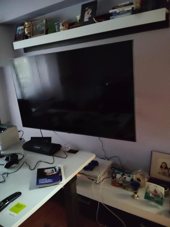 una scrivania con una grande TV su un muro di Apartament Gya a Lupeni