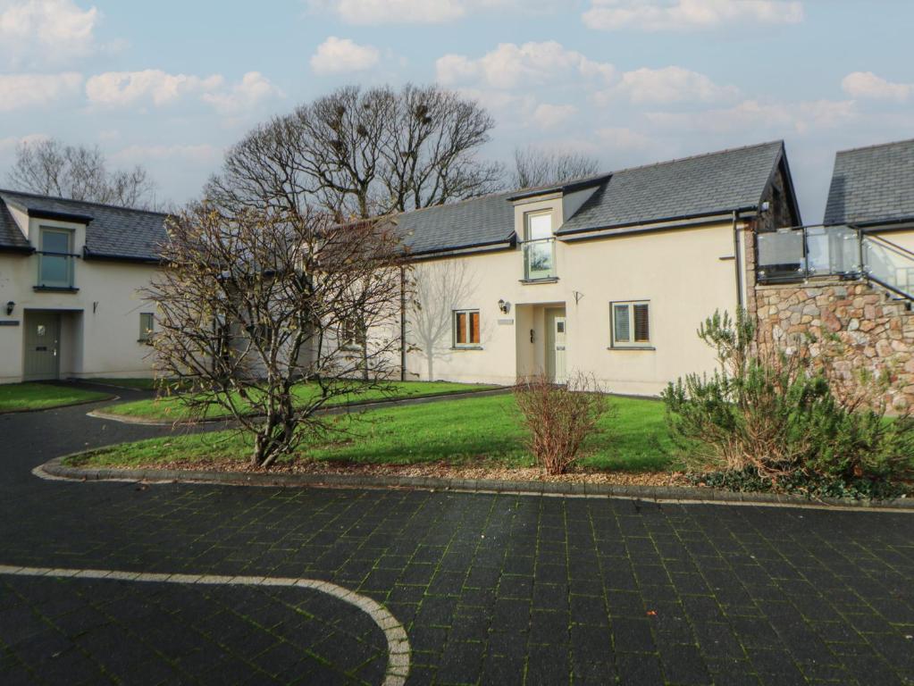 a white house with a driveway in front of it at Willow Apartment - Gower in Swansea