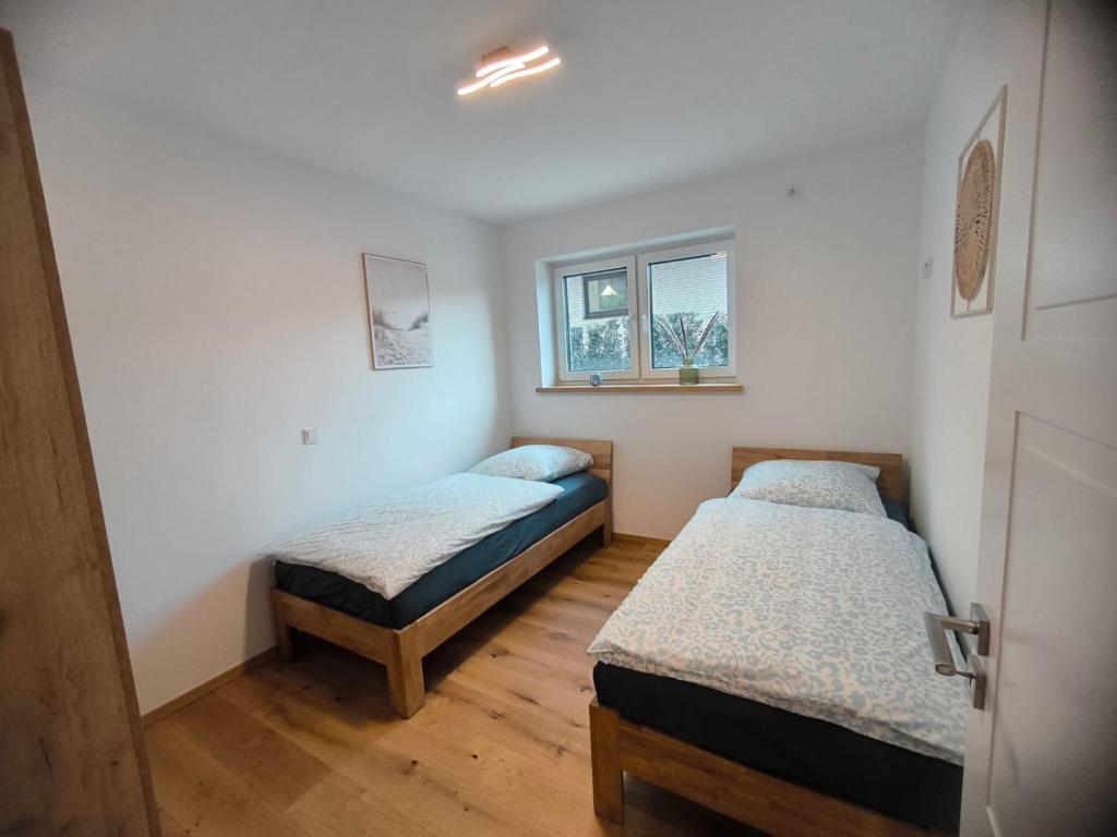 SeeZeitApartments Whg 30 في ليمبروتش: سريرين في غرفة بها نافذة