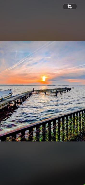 a picture of a pier in the ocean at sunset at Woonboot De Witte loosdrechtse plassen in Loosdrecht