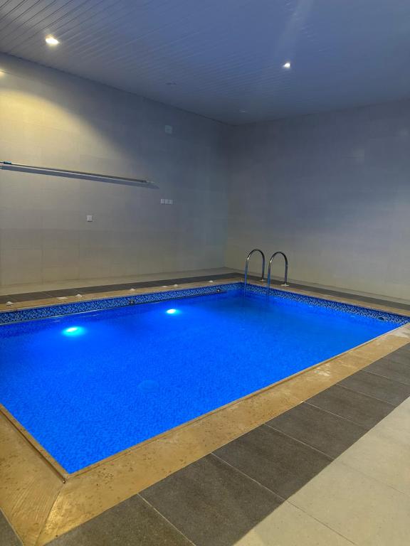 una grande piscina con acqua blu in una stanza di شاليهات روز a Al Shafa