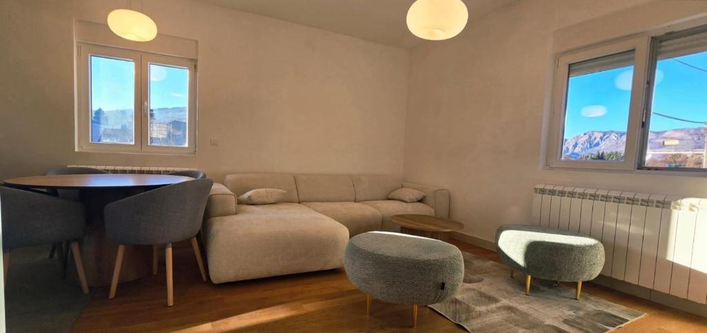 een woonkamer met een bank, een tafel en stoelen bij North & South Escape Kolašin in Kolašin