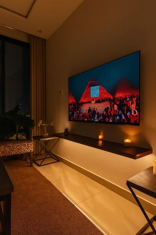 a living room with a large flat screen tv on the wall at Daró - Self Check-in - 1 BR Apartment - Gulberg - MM Alam - Pool in Lahore