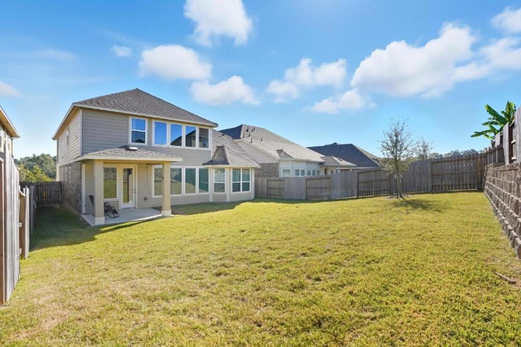 ein Haus mit einem Hof mit einem Zaun in der Unterkunft Near Lake Conroe • Private Yard • Pet Friendly in Keenan