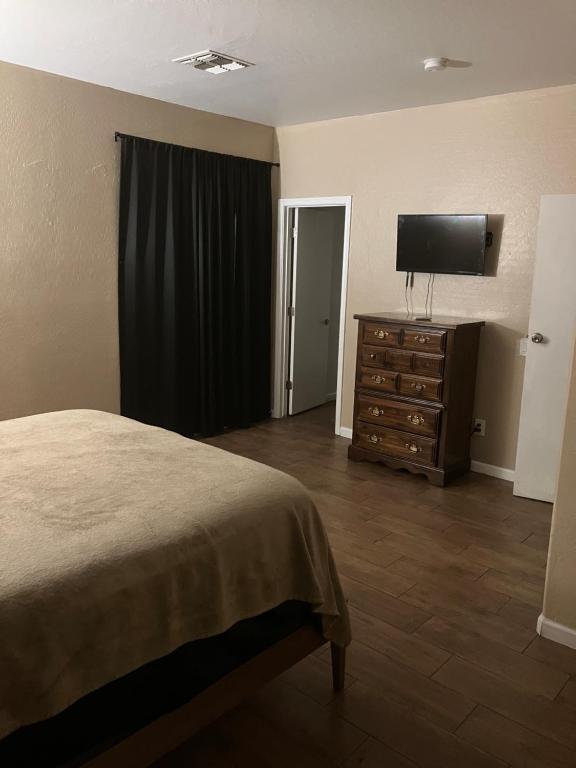 a bedroom with a bed and a dresser with a flat screen tv at West Phoenix Mini Master Bennet in Phoenix