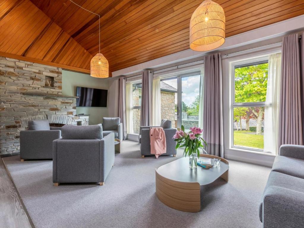 a living room with couches and a table and windows at 3 Bed in Saltash oc-87711 in St. Mellion