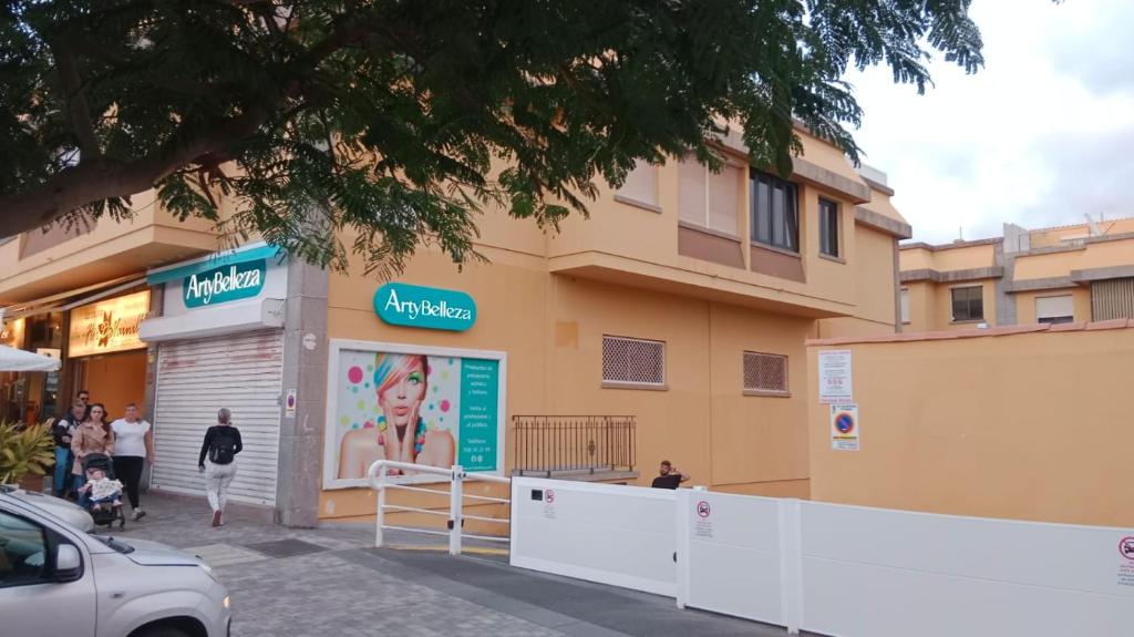 a woman walking in front of a building at La posada del sur in San Bartolomé de Tirajana
