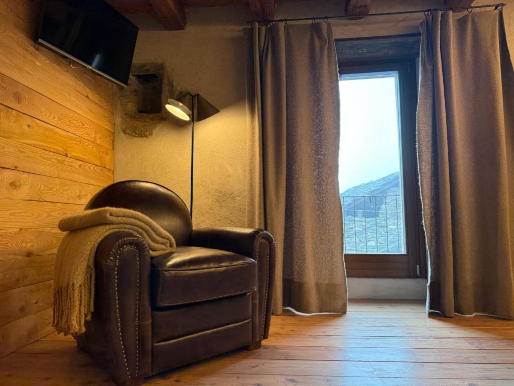 a leather chair in a room with a window at Mansio 1695 Chambres d'hôtes in Pont-Saint-Martin