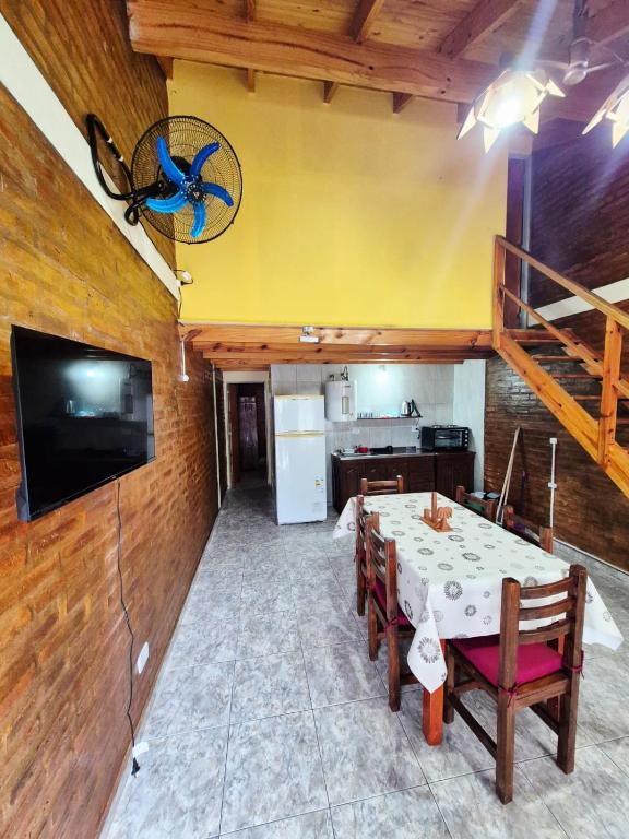 a dining room with a table and a tv on a wall at Cabañas La Carlota in Trapiche