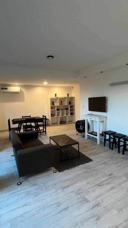 un salon avec un canapé, des tables et une télévision dans l'établissement Dúplex con Garage Esperanza, à Esperanza