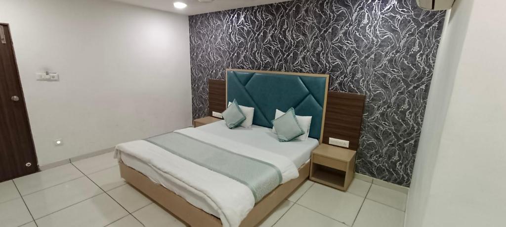 a bedroom with a bed with a blue headboard at Hotel Nest View In in Ahmedabad