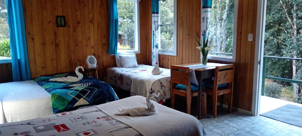 een slaapkamer met twee bedden en twee zwanen op de bedden bij Miriam'S Quetzals lodge in San Gerardo de Dota