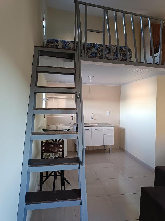 a ladder leading up to a room with a bunk bed at Loft confortável in Morro do Chapéu
