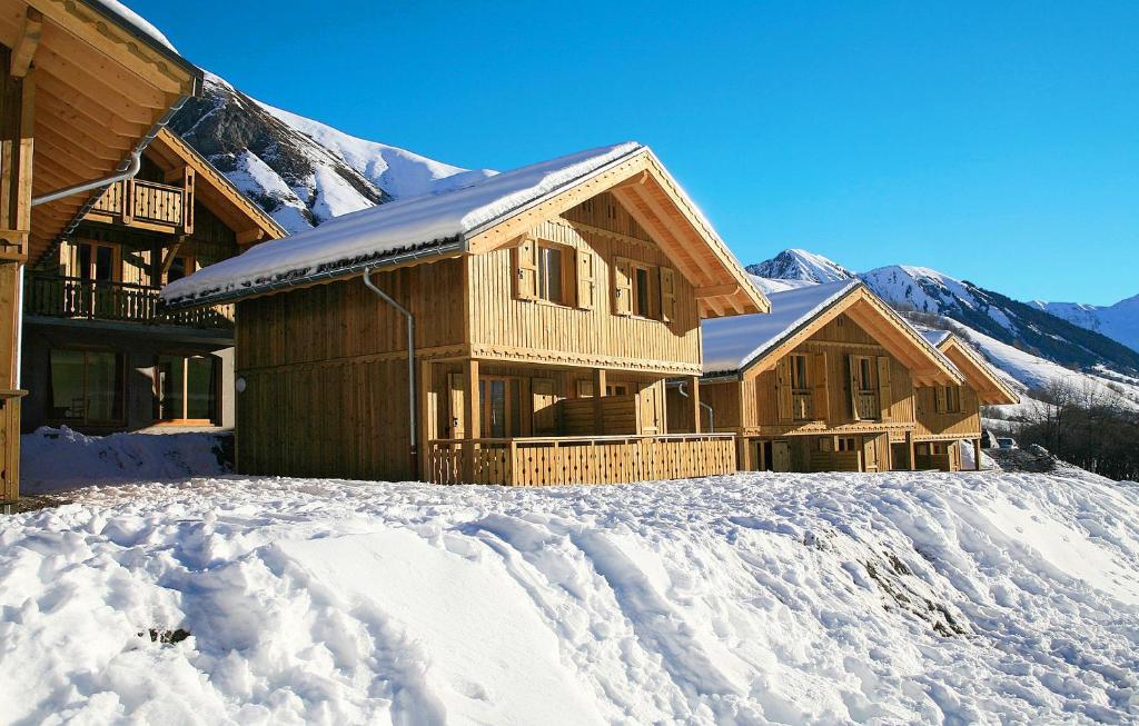 ein Blockhaus im Schnee mit Bergen im Hintergrund in der Unterkunft Résidence Odalys Les Chalets de l'Arvan II in Saint-Sorlin-dʼArves