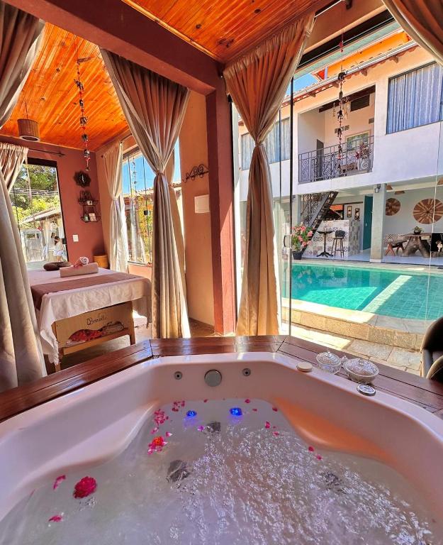 a large bath tub in a room with a pool at SPA&Hospedagem Giovannini Massagem inclusa in Pirenópolis